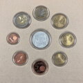 Rozloženie mincí v etui a strieborný žeton.