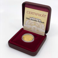 Zlatá medaila uložená v bordovej etui s certifikátom.
